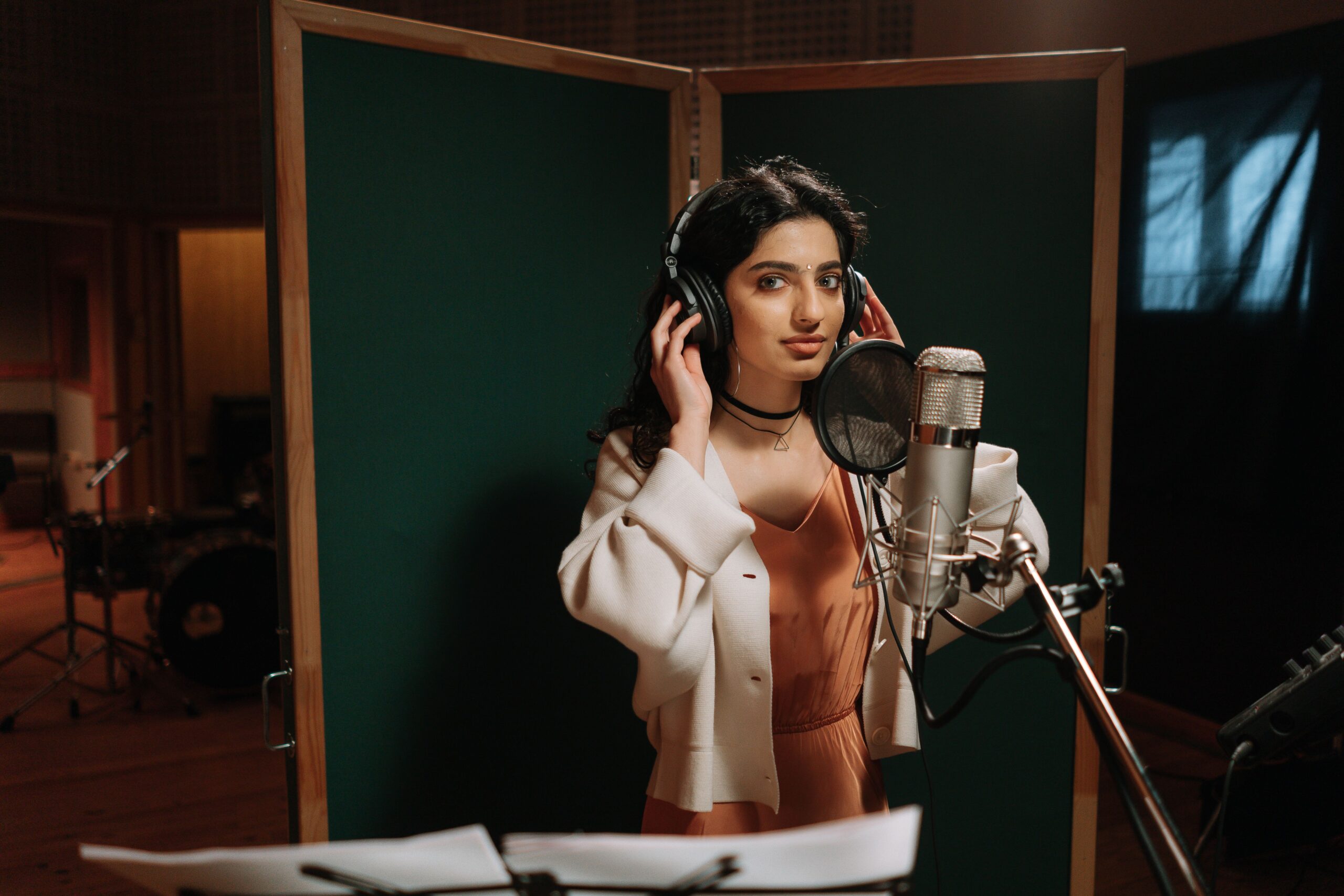 Sponsor A Singer A female musician recording vocals in a professional music studio.